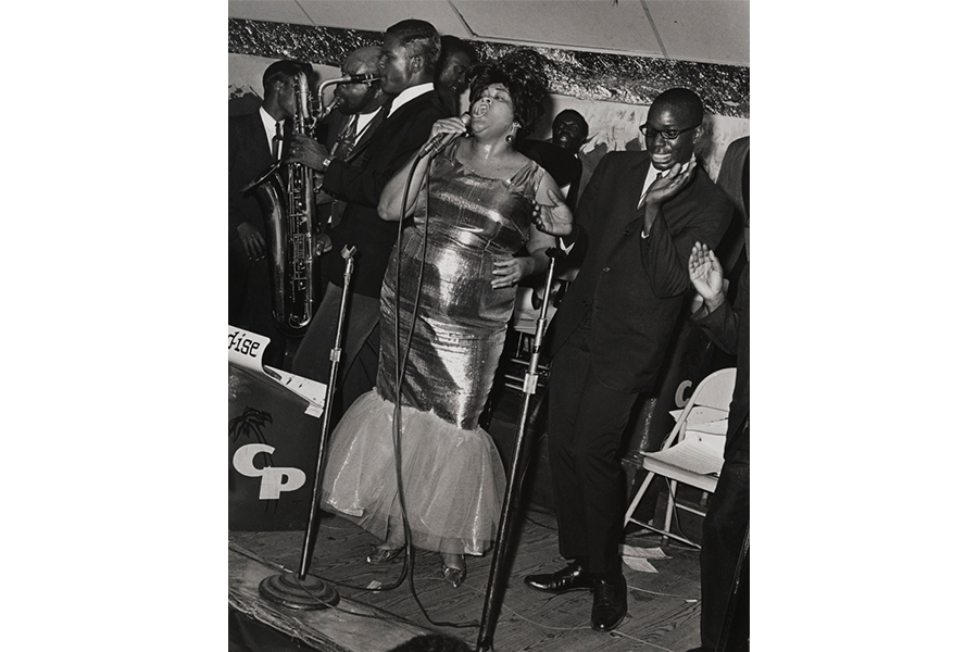 Black and white photography of Ella Fitzgerald signing center in front of a full band