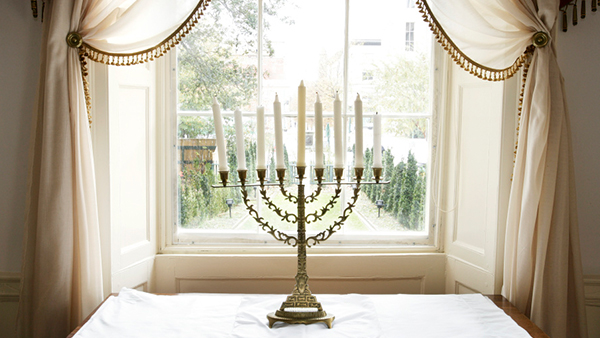 Menorah in front of a brightly lit window