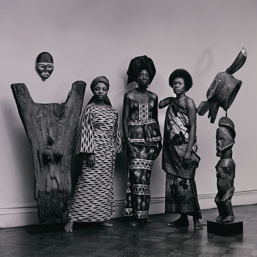 Women posing with statues