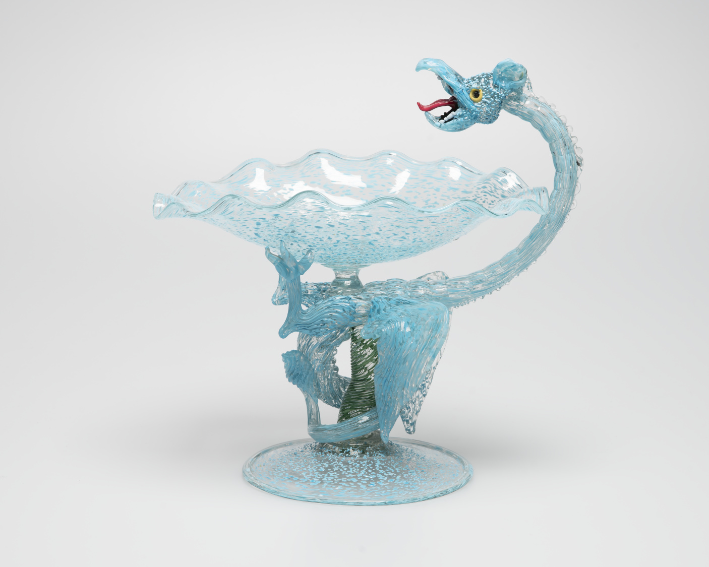 Intricate glass vessel. A speckled dragon, spirals up the stem creating a handle.