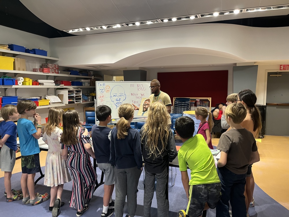 Kids listening to instruction from artist Chris Green