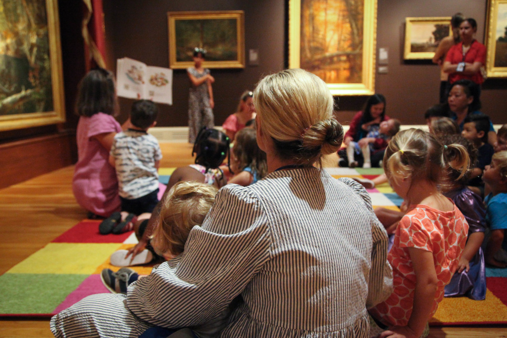 Children and families listening to reading in the galleries