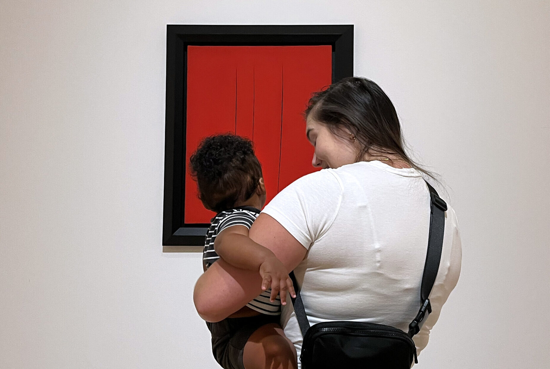 Mother and child interacting in front of art.