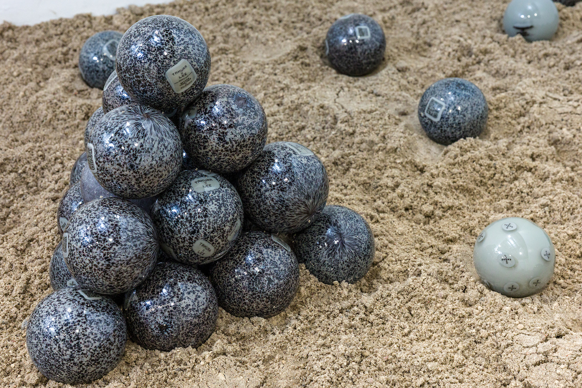 marbles stacked in a pyramid in sand