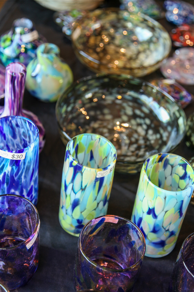 Glass items for sale on table.