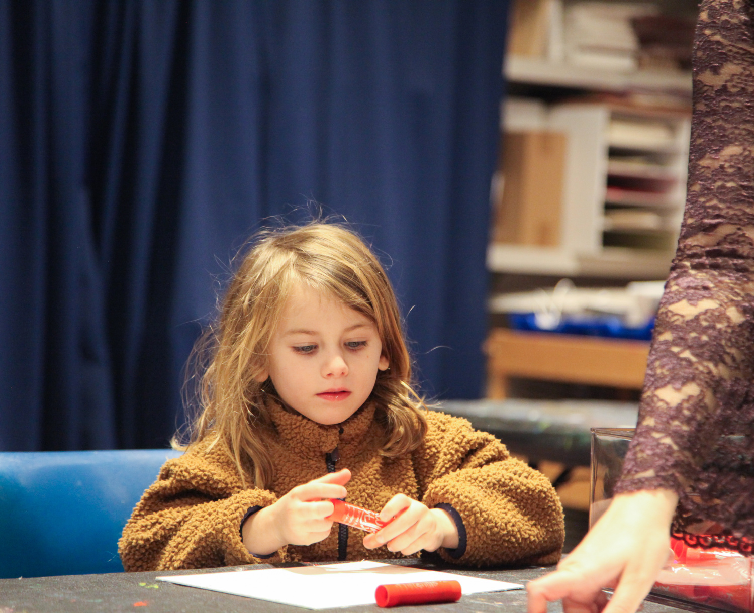 Child participating in art making activity at pre-k art play