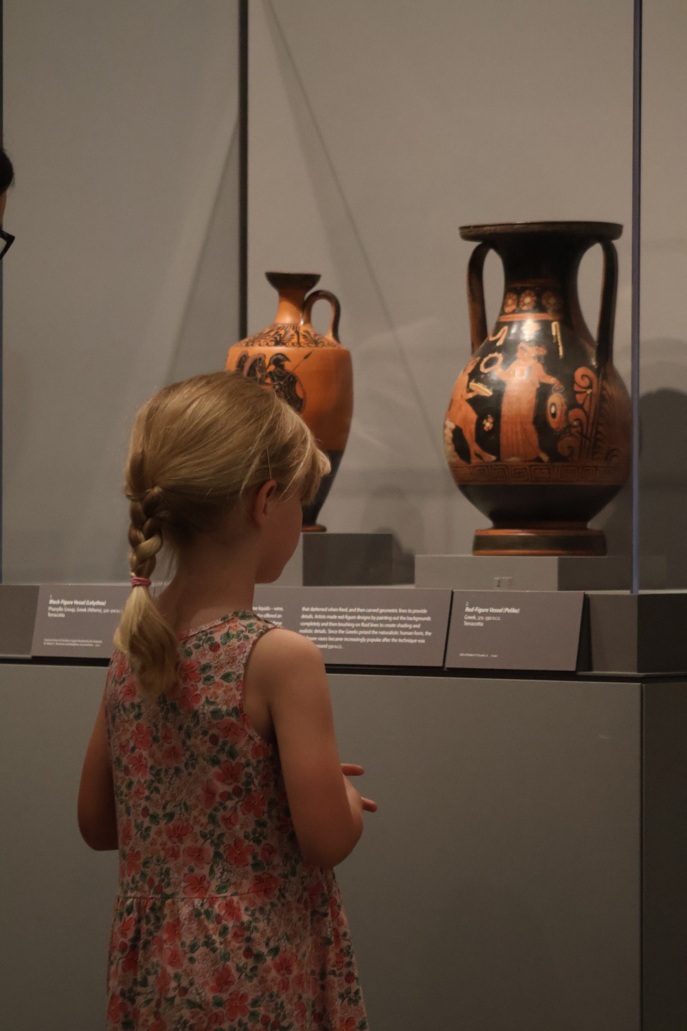Child viewing vase in gallery