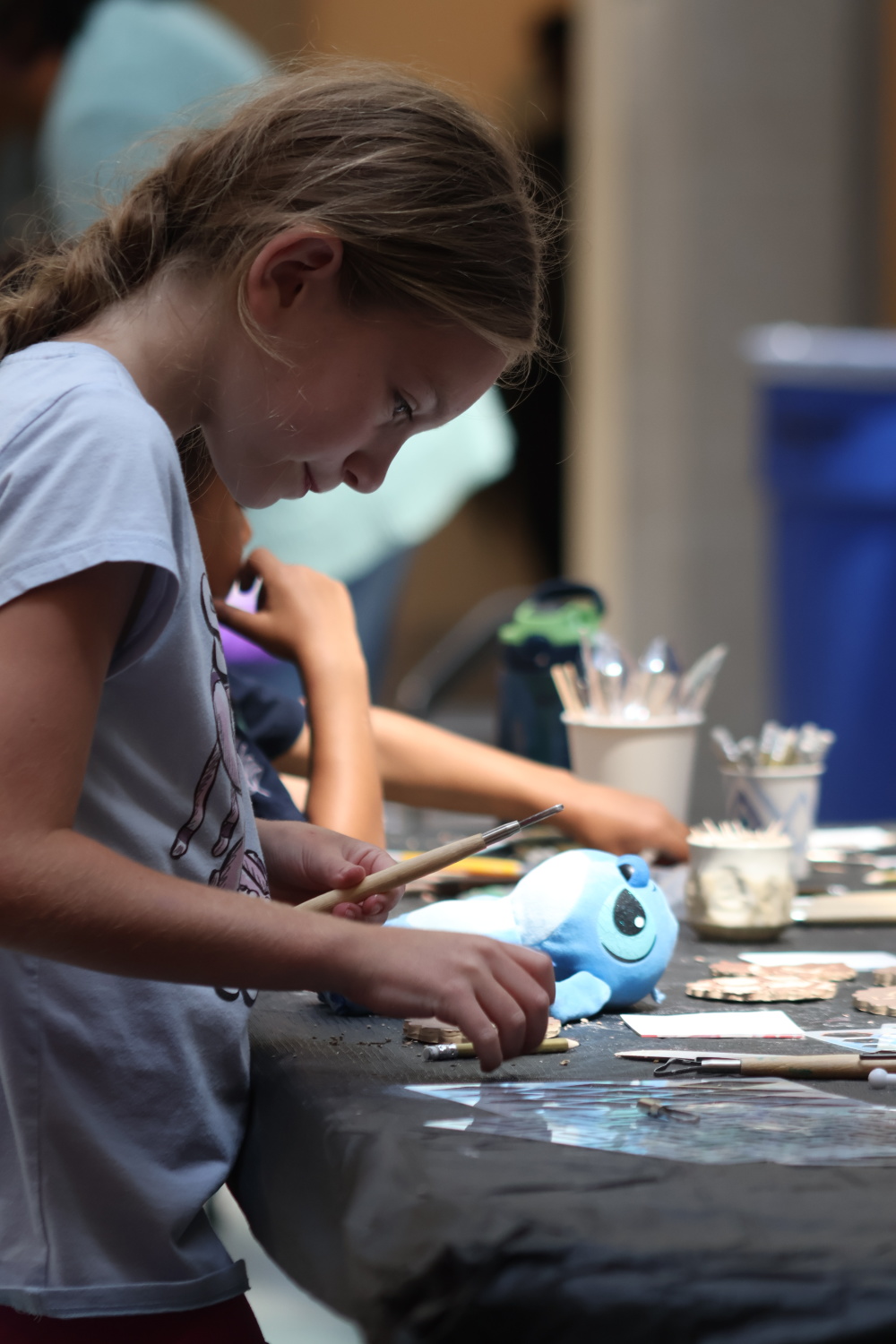 Child participating in art making activity in education workshop