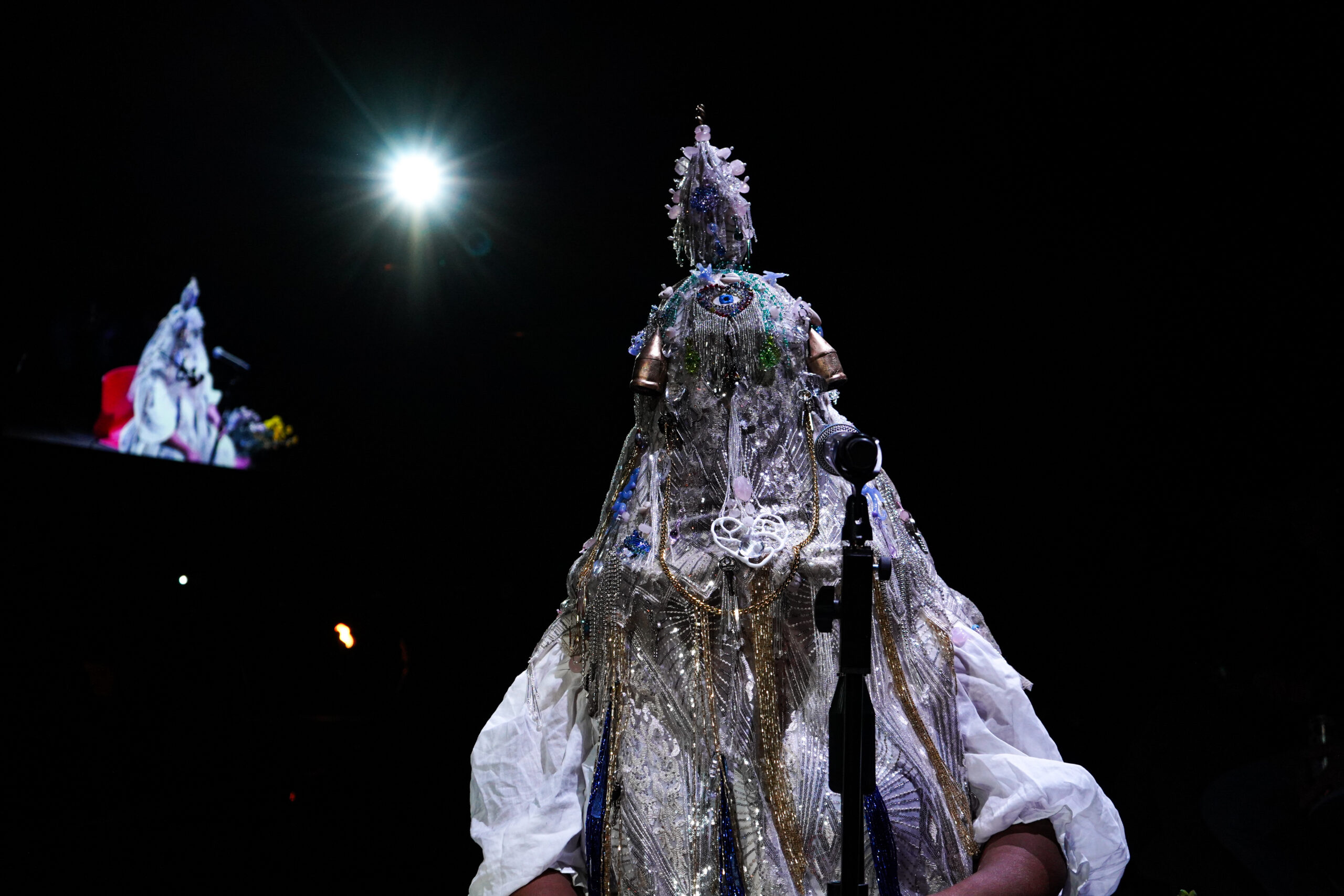 vanessa german wears a masked costume made out of beads, emroidery, and found materials.