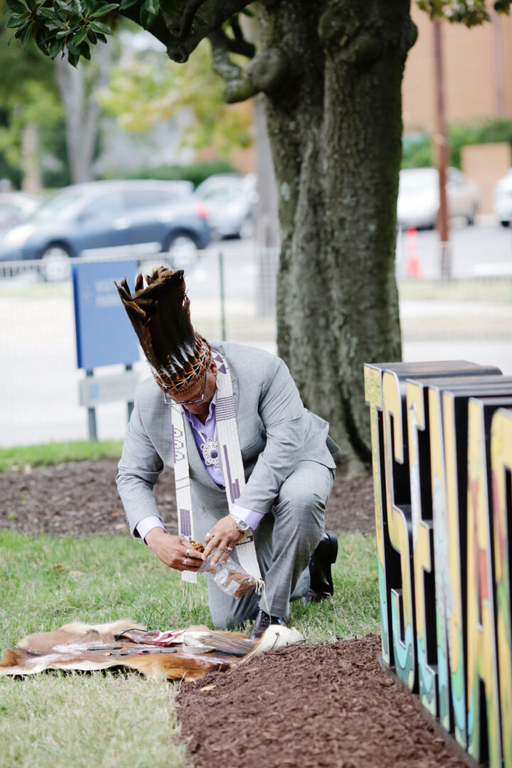 Man kneeling in front of art installation