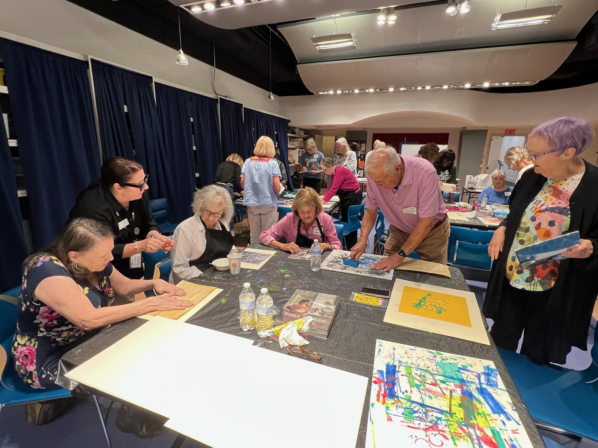 Older adults participating in and artmaking activity in the education workshop