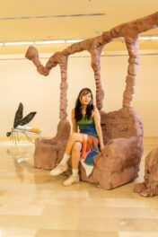 Libbi Ponce appears as a confident young woman sitting amongst a contemporary art installation.
