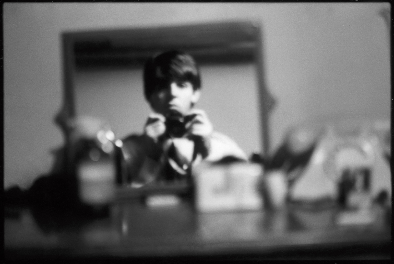 Paul McCartney photographs his reflection in a mirror.